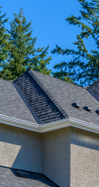 Roofer inspecting hail damage on a Centennial, CO roof